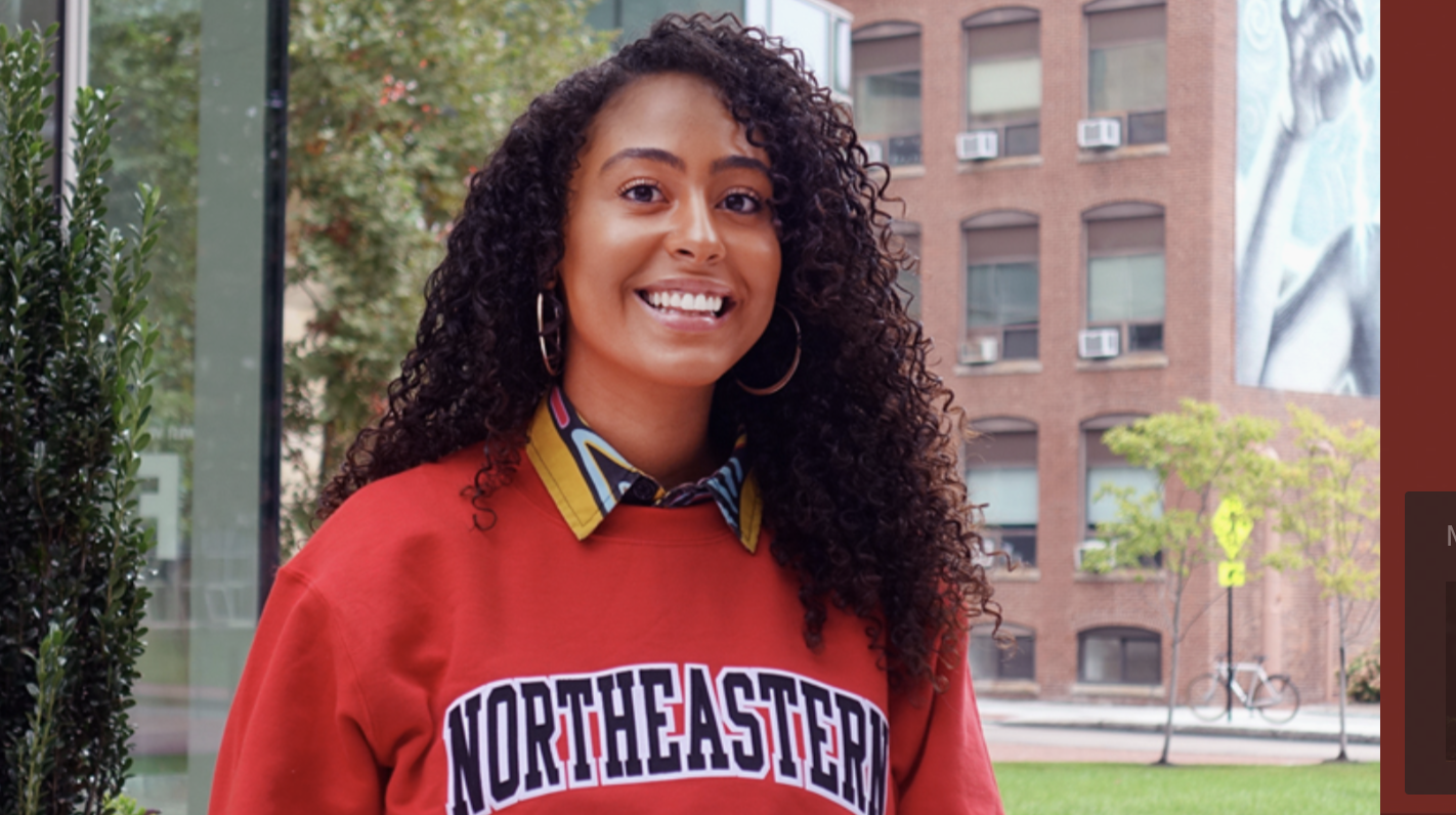 Health science student smiling outside Behrakis Health Sciences building at Northeastern University